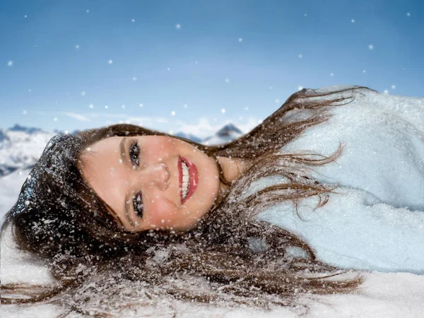 Woman smiling and laying in snow — Stock Photo, Image