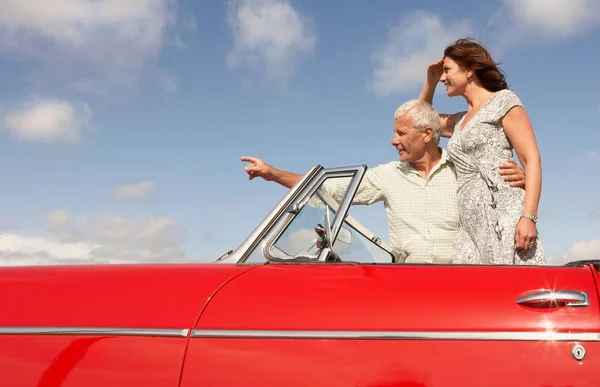 Vanhempi pari seisoo urheiluauto — kuvapankkivalokuva