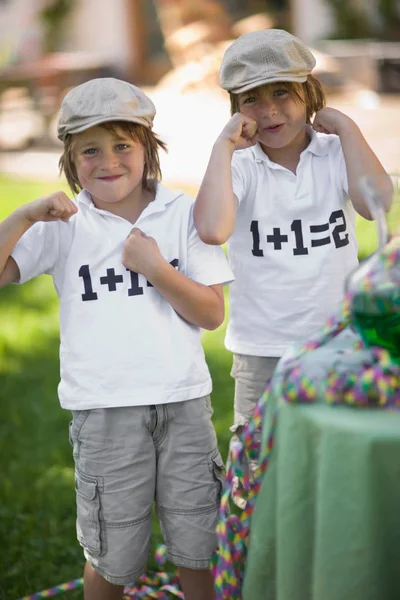 Bliźniaczki, stojąc w identycznych koszulki i Wyświetlono pięści — Zdjęcie stockowe