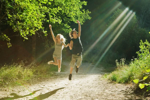 Casal saltando na floresta — Fotografia de Stock