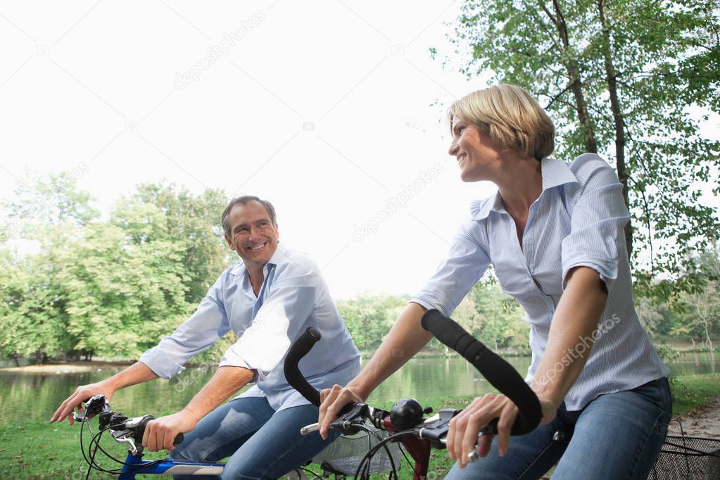 Middle aged couple riding bicycles