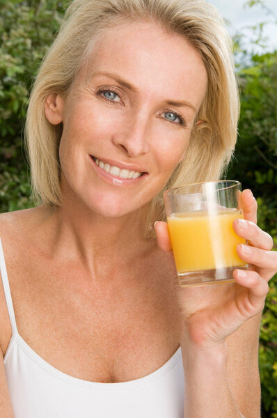 Portrait of mid adult pretty caucasian woman with orange juice