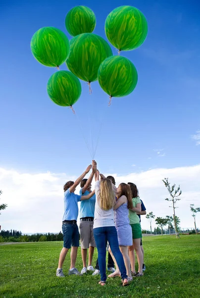 Adolescentes Sosteniendo Globos Helio Verde —  Fotos de Stock