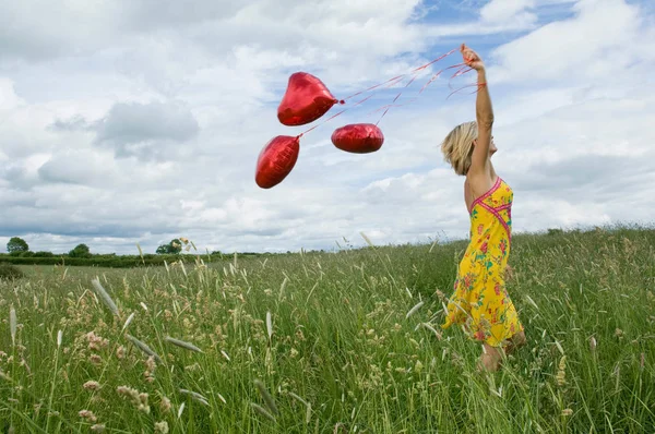 中成年漂亮的白种女人在野外散步气球 — 图库照片