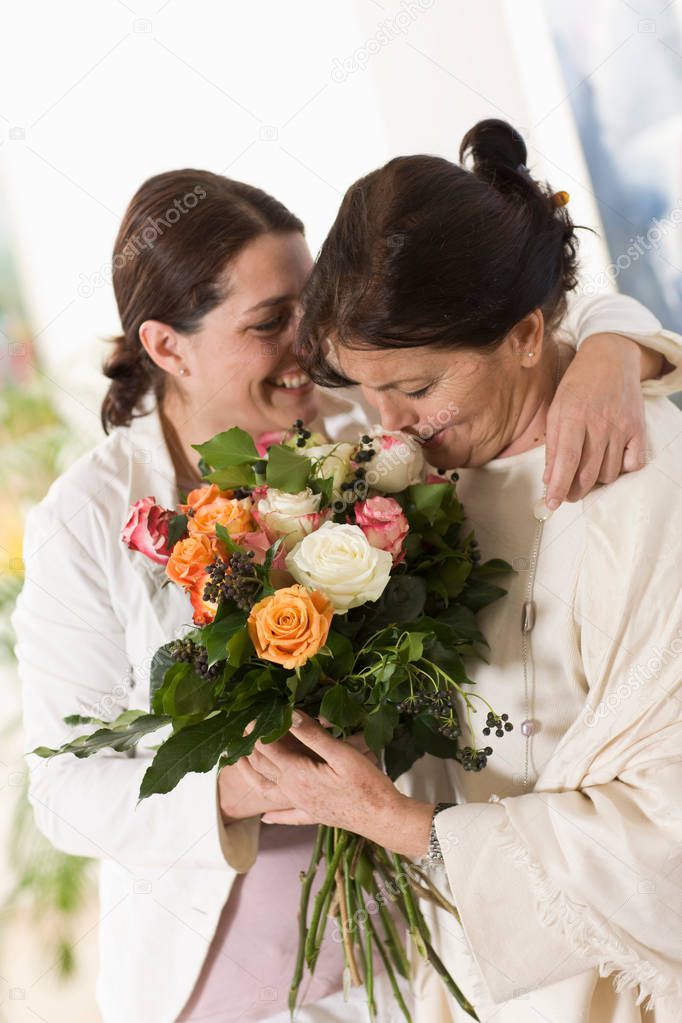 Daughter giving her mother flowers