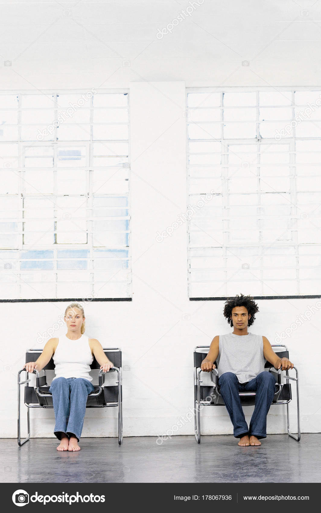 Couple Sitting On Separate Chairs Stock Photo