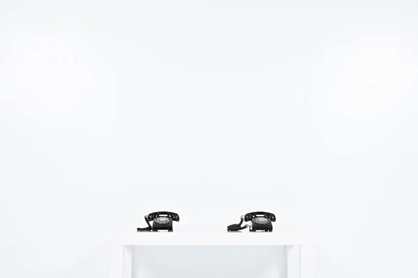 Δύο Τηλέφωνα Vintage Μαύρο Τοποθετούνται Λευκό Τραπέζι Κοντά Τοίχο — Φωτογραφία Αρχείου