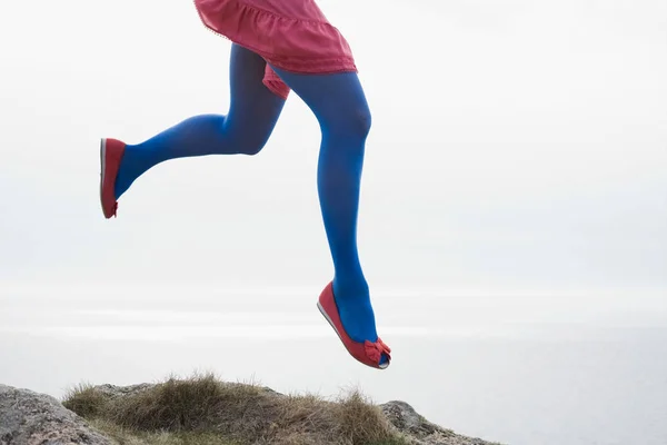 Женщина прыгает на скалах — стоковое фото