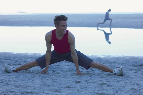 Amigos haciendo ejercicio en la playa de arena —  Fotos de Stock