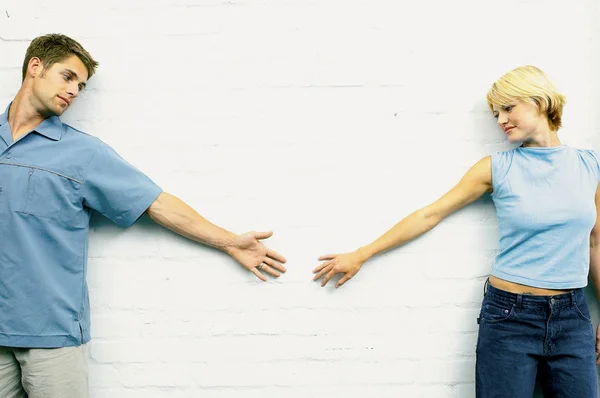 Пара, опирающаяся на стену и вытянутые руки — стоковое фото