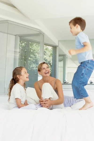Mother Daughter Looking Boy Jumping Bed — Stock Photo, Image