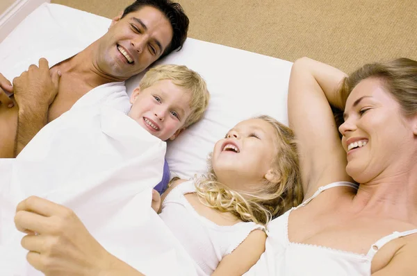 Aile Yatakta Gülümsüyor — Stok fotoğraf