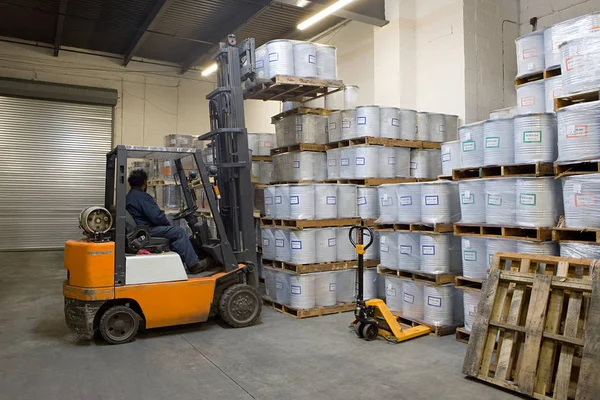 Fork lift driver lifting pallets