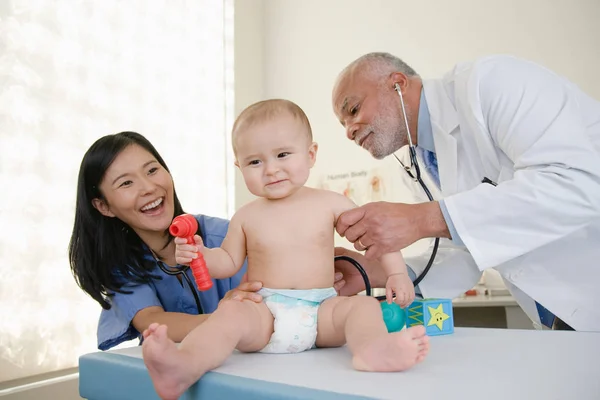 Ένας Γιατρός Και Ένας Νοσοκόμος Που Εξετάζουν Ένα Μωρό — Φωτογραφία Αρχείου