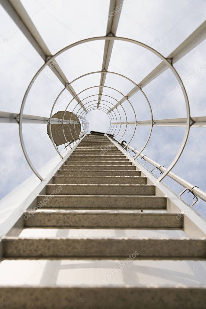 Low angle view of high ladder against blue loudy sky 