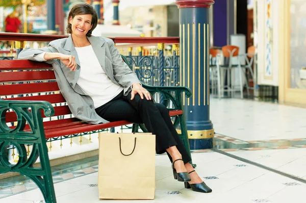 Kvinnan Som Sitter Bänken Med Shopping Väska — Stockfoto