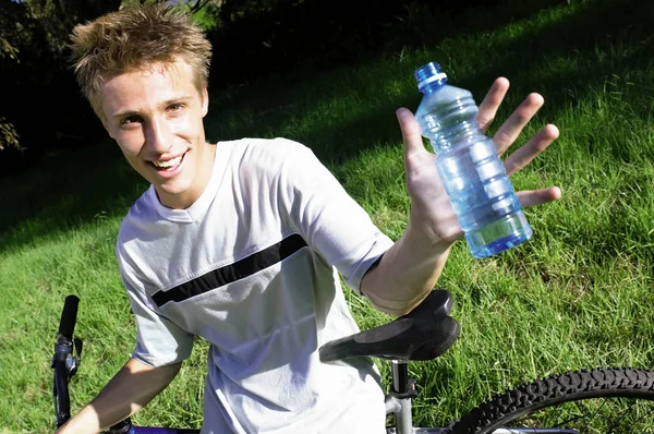 Fiú kerékpár tartó üveg víz — Stock Fotó