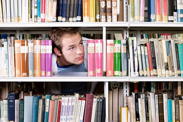 Student Schaut Durch Bücherregal — Stockfoto