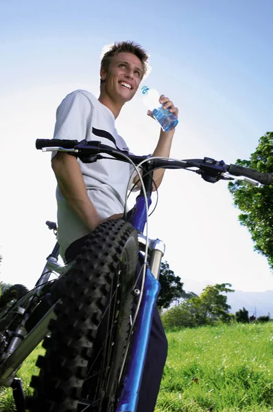 Boy with bike drinking water Stock Image