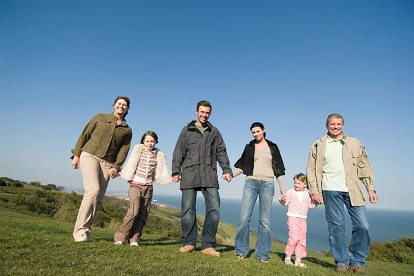 Familie Hält Händchen Auf Einem Grashügel — Stockfoto