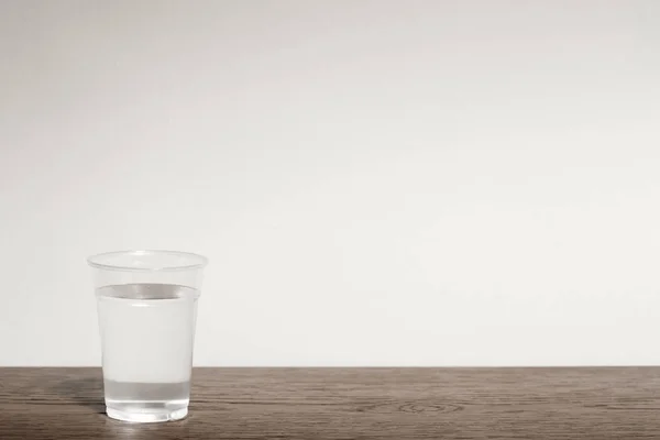 Água Uma Xícara Plástico Mesa Madeira — Fotografia de Stock