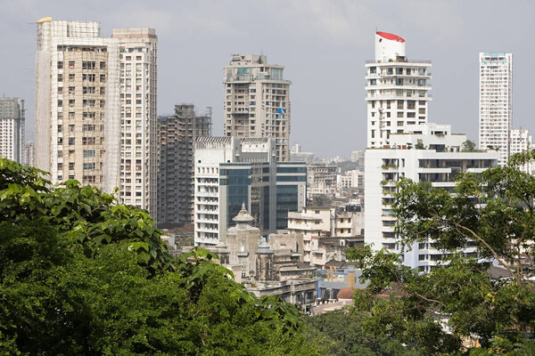 Aerial view of skyscrapers and cityscape of Mumbai with trees on foreground