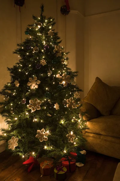 Δώρο Κουτιά Κάτω Από Στολισμένο Χριστουγεννιάτικο Δέντρο Και Πολυθρόνα Στέκεται — Φωτογραφία Αρχείου