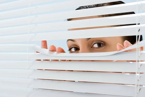 Vrouw Kijkt Door Blinds — Stockfoto