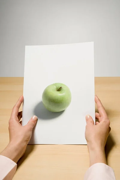 Frau Hält Foto Von Apfel Auf Holztisch — Stockfoto