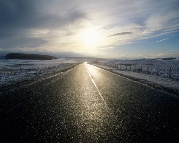Vooraanzicht Van Landelijke Weg Tussen Besneeuwde Velden Met Zon Wolken — Stockfoto