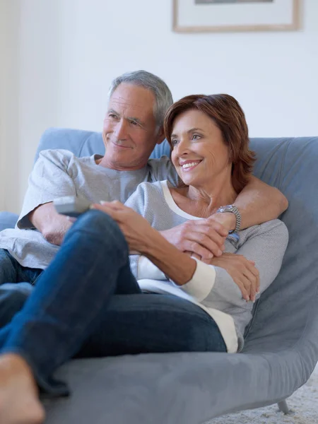 Atractiva Pareja Ancianos Abrazándose Sofá Viendo Televisión —  Fotos de Stock