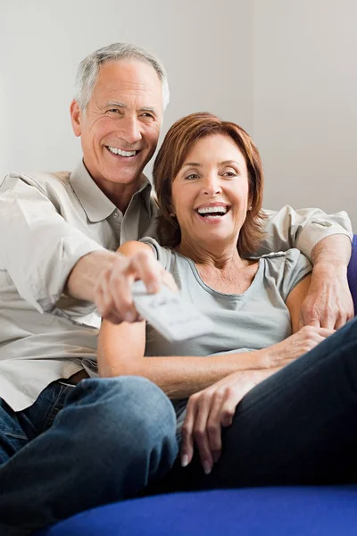 Atractiva Pareja Ancianos Abrazándose Sofá Viendo Televisión —  Fotos de Stock