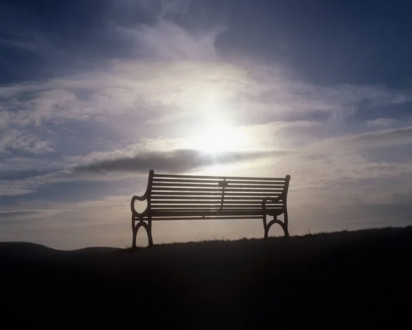 Vista Trasera Del Banco Con Sol Cielo Nublado Sobre Fondo —  Fotos de Stock