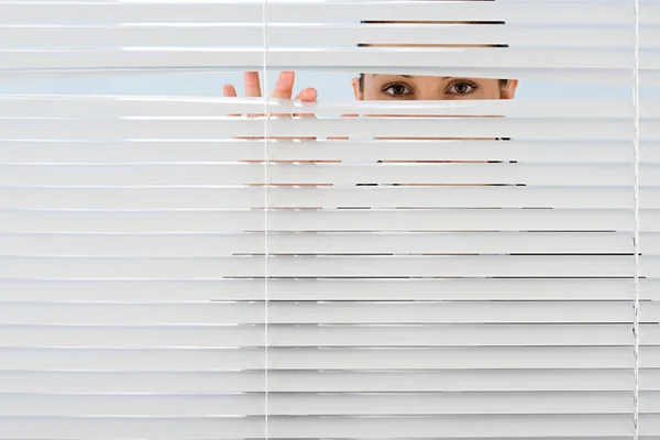 Woman Looking Though Blinds — 스톡 사진
