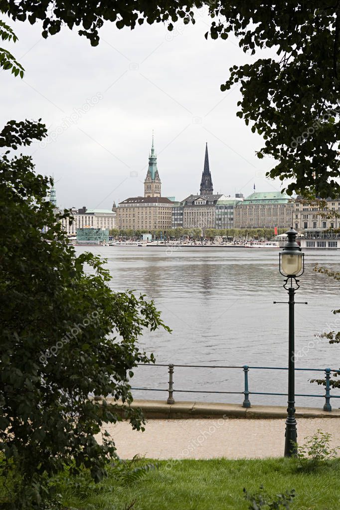 Lake Alster with Hamburg cityscape with rainy clouds on background
