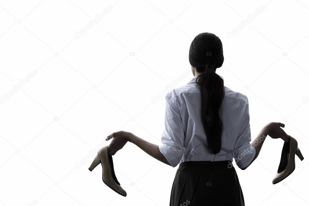 rear view of young beautiful successful businesswoman holding high heeled shoes