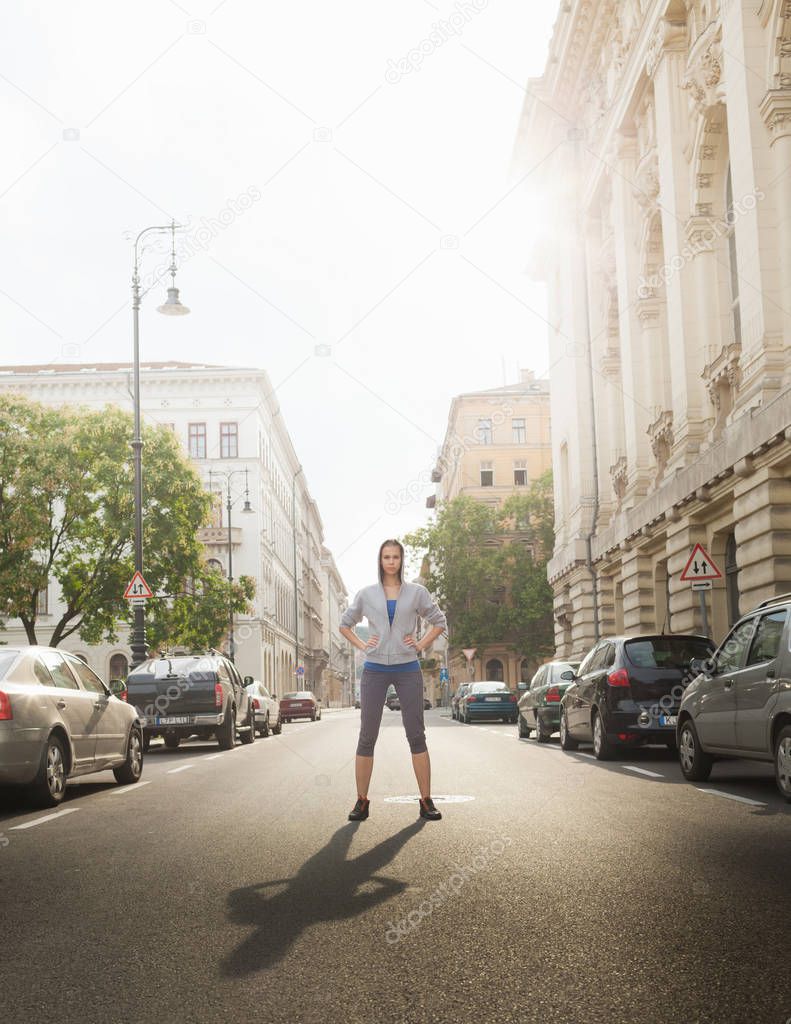 pretty young sporty woman standing on city street