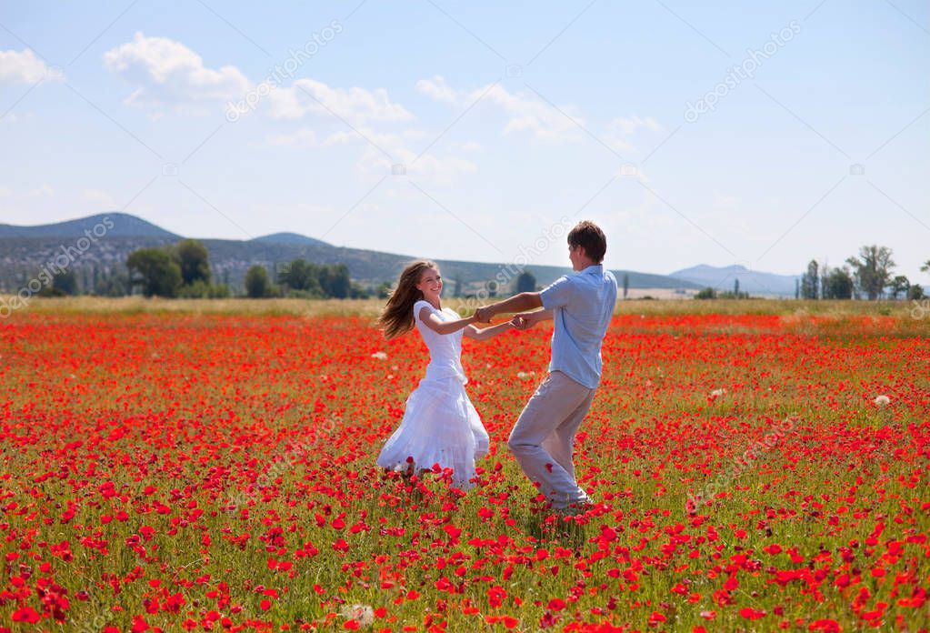 Couple playing in field of poppies