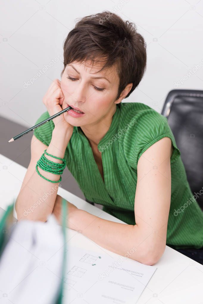 Woman chewing a pencil
