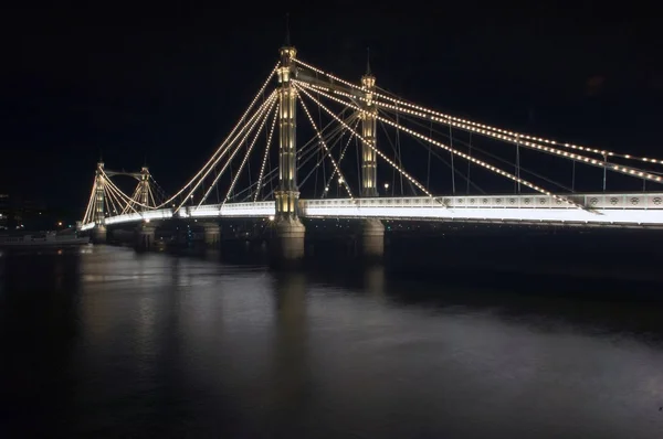 阿尔伯特大桥在夜晚和泰晤士河上灯火通明 — 图库照片