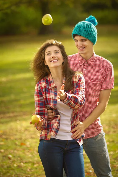 十几岁的夫妇在公园里玩苹果 — 图库照片