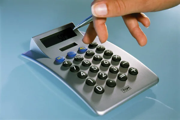 Przycięte Strzał Osoby Rękę Pomocą Kalkulatora Niebieskim Tle — Zdjęcie stockowe