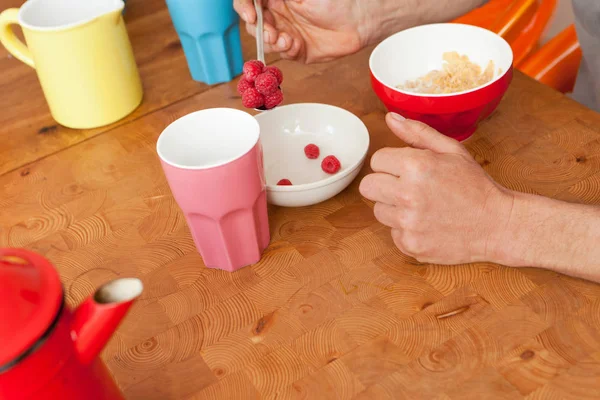 朝食にラズベリーと穀物の男性の手の画像をトリミング — ストック写真