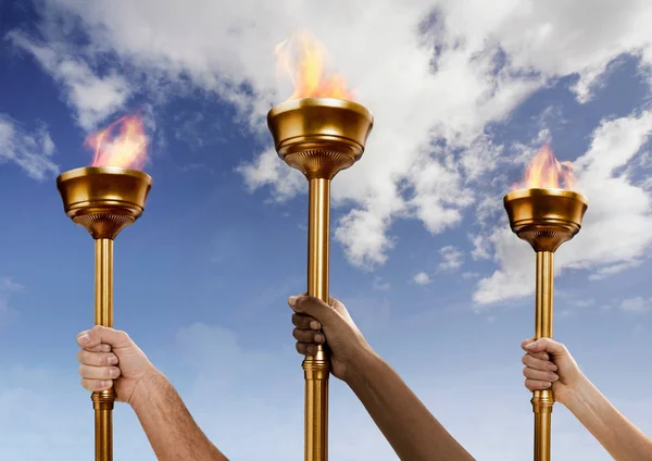 Hands holding flaming batons