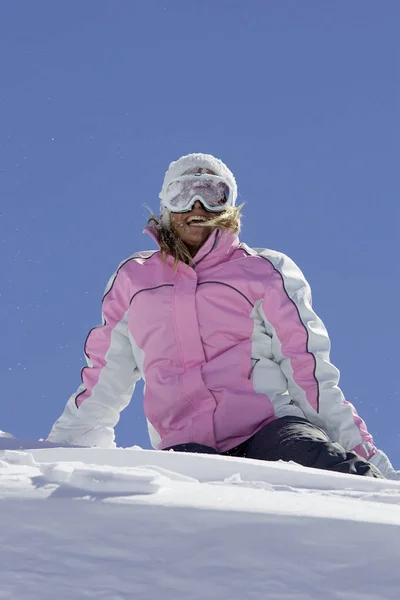 山の斜面の上に座って冬の服装の中で白人女性スキーヤー — ストック写真