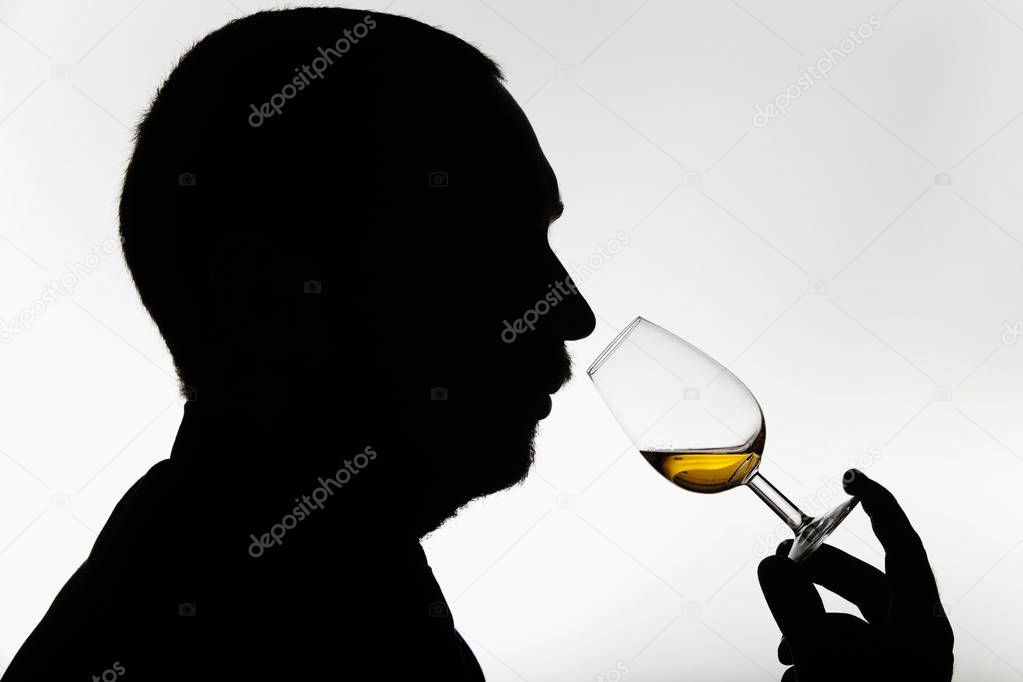 Worker smelling whisky in distillery