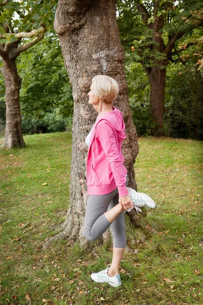 公園に足を伸ばす上級スポーティな白人女性 — ストック写真