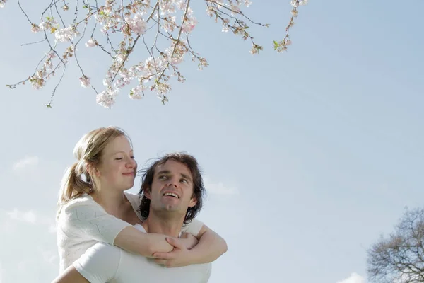在樱花树下的中年迷人的高加索情侣拥抱 — 图库照片