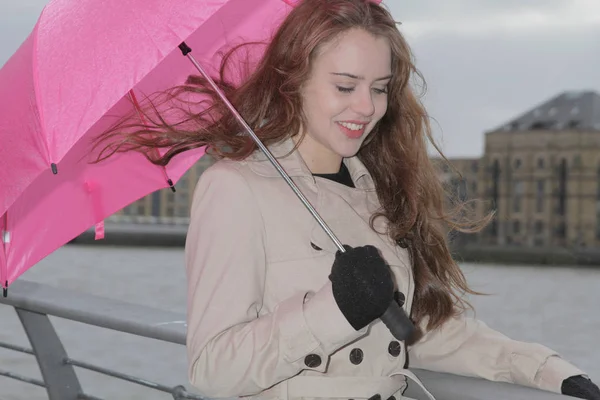ピンクの傘を持つ若い女 — ストック写真