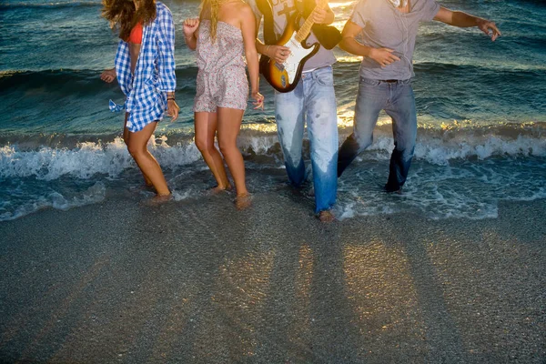 ビーチの潮でギターとグループ ダンスのトリミングされた画像 — ストック写真